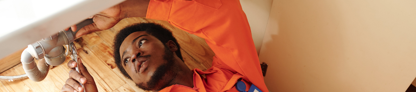 Plumber working on a sink waste pipe in Dover, Kent