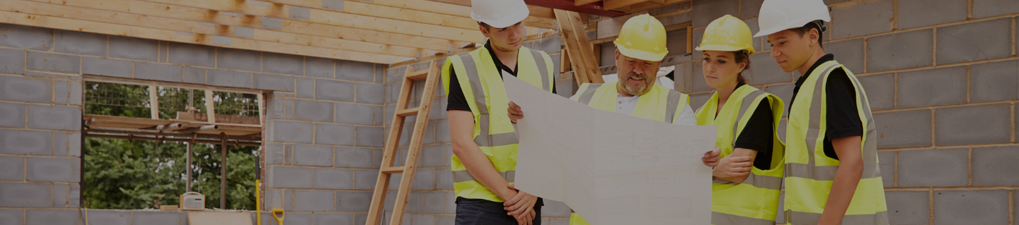 A group of builders standing together looking at a plan