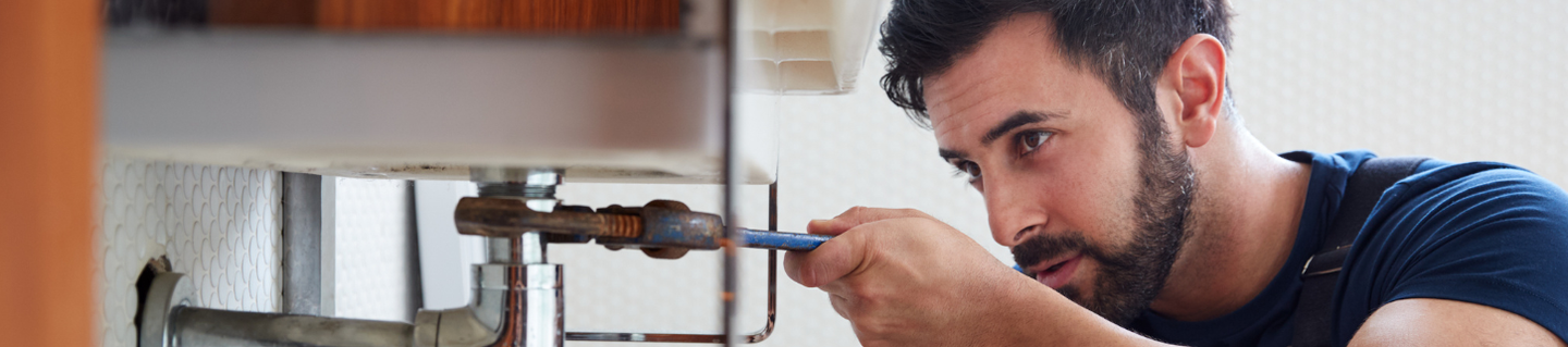 Plumber fixing a pipe with a wrench in Dartford, Kent